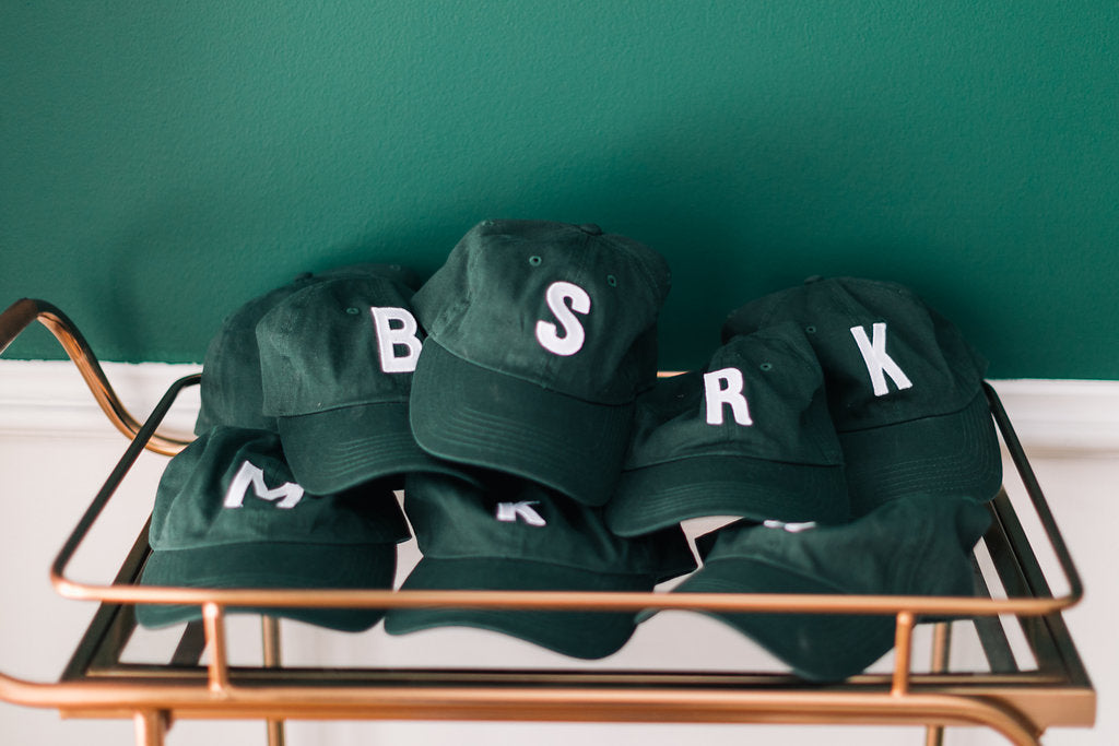 green baseball cap with custom letter